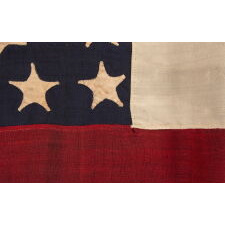 WAR-PERIOD CONFEDERATE FLAG IN THE FIRST NATIONAL PATTERN (a.k.a., STARS & BARS), IN A TINY SIZE, WITH AN ELONGATED PROFILE, AND 11 STARS ARRANGED IN AN UNUSUAL, RECTANGULAR MEDALLION; ENTIRELY HAND-SEWN, MADE BETWEEN MAY - NOVEMBER, 1861