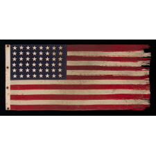 AMERICAN FLAG, 48 STARS, A U.S. NAVY SMALL BOAT ENSIGN FROM A WWII SUBMARINE, WITH ENDEARING WEAR FROM LONG-TERM USE; THE FLAG MADE IN JANUARY, 1944 AT MARE ISLAND, CALIFORNIA; BROUGHT HOME BY GUNNER’S MATE 2ND CLASS, JAY J. BURKINS OF LANCASTER COUNTY, PENNSYLVANIA