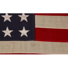ANTIQUE AMERICAN FLAG WITH 48 STARS, A U.S. NAVY SMALL BOAT ENSIGN, MADE IN JANUARY OF 1944, DURING WWII (U.S. INVOLVEMENT 1941-45), AT MARE ISLAND, CALIFORNIA, FORMER HEADQUARTERS OF THE PACIFIC FLEET, WITH ENDEARING WEAR FROM LONG-TERM USE