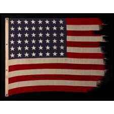 ANTIQUE AMERICAN FLAG WITH 48 STARS, A U.S. NAVY SMALL BOAT ENSIGN, MADE IN JANUARY OF 1944, DURING WWII (U.S. INVOLVEMENT 1941-45), AT MARE ISLAND, CALIFORNIA, FORMER HEADQUARTERS OF THE PACIFIC FLEET, WITH ENDEARING WEAR FROM LONG-TERM USE
