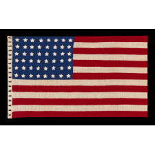 48 STARS ON A CROCHETED AMERICAN FLAG, PROBABLY MADE IN THE PATRIOTISM OF WWII (U.S. INVOLVEMENT 1941-1945), A BEAUTIFUL EXAMPLE WITH STRIKING COLORS, LARGER THAN TYPICAL IN SCALE, WITH AN INTERESTING, REPEATING, OPEN PATTERN ALONG THE HOIST, THROUGH WHICH A STAFF COULD BE THREADED